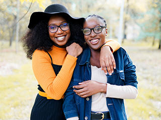 Two young Black women smiling and posing for a candid