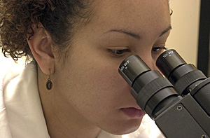 Woman scientist looking into microscope
