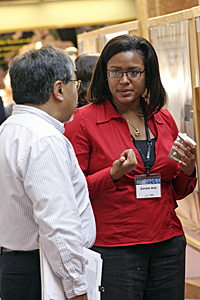 Woman talking to scientist in front of science project