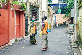Health department workers of KMC (kolkata municipal corporation) waiting outside a residential house, for spraying disinfection liquid to stop the spread of mosquito born diseases