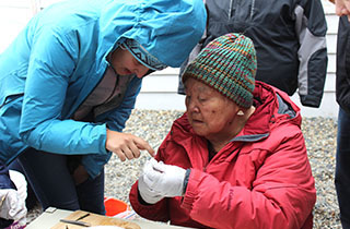 Harriet Penayah, right, an elder from St. Lawrence Island, and intern Abigail Nelson, working at the community-based research institute in Gambell, Alaska