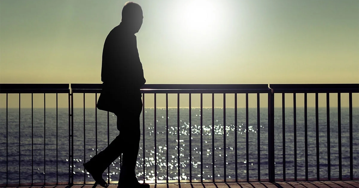 older adult walking next to the ocean