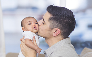 Man kissing a baby on the cheek