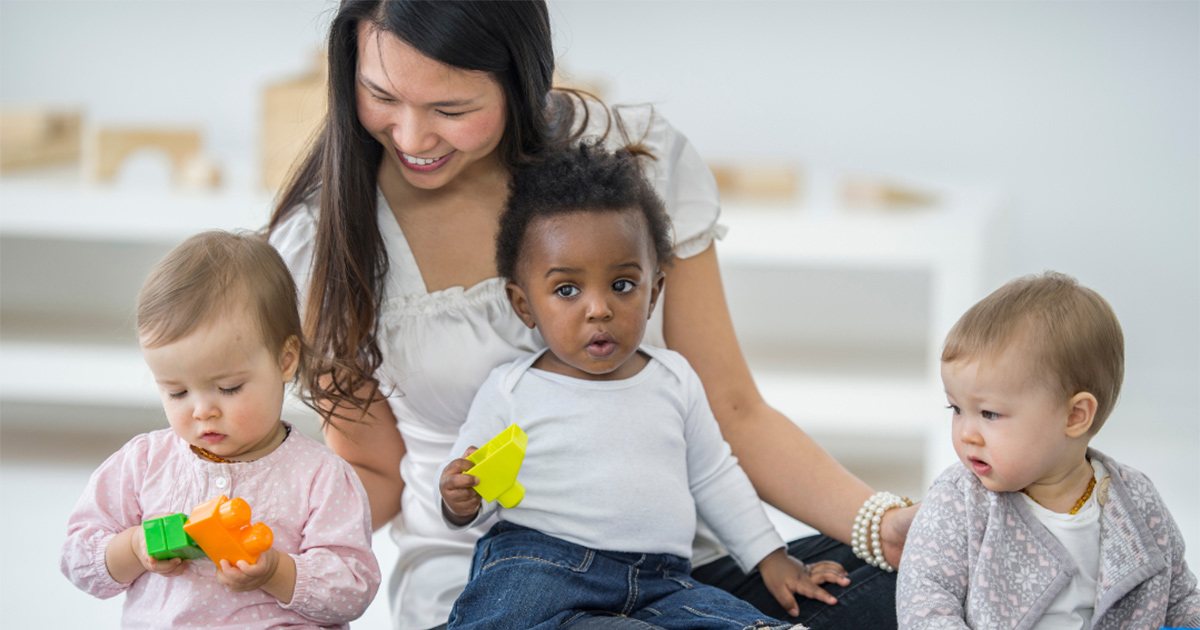 Young woman playing with babies