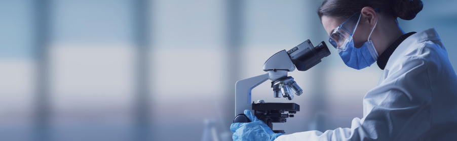 scientist looking through microscope