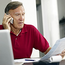 man on phone while looking at papers