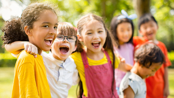Multi-ethnic group of school children laughing and embracing