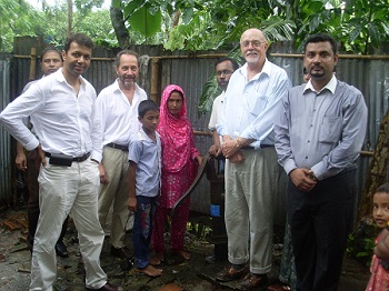Men, women, and children posing in front of a well