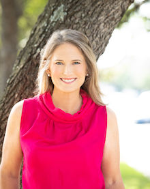 Elena Craft in red shirt, standing in front of tree