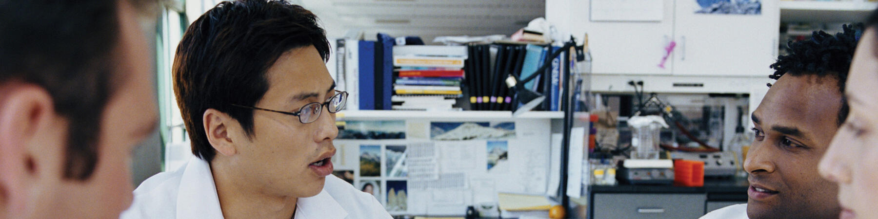 Young scientists sitting at table and talking with each other