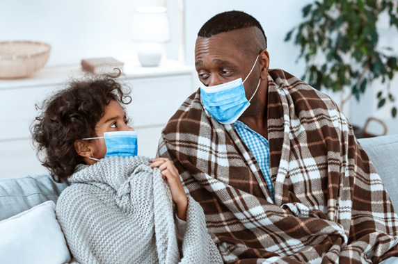 girl and a man wearing protective masks at home