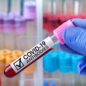 hand holding COVID-19 blood antibodies in a tube