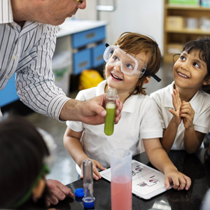 students watching teacher perform science experiment