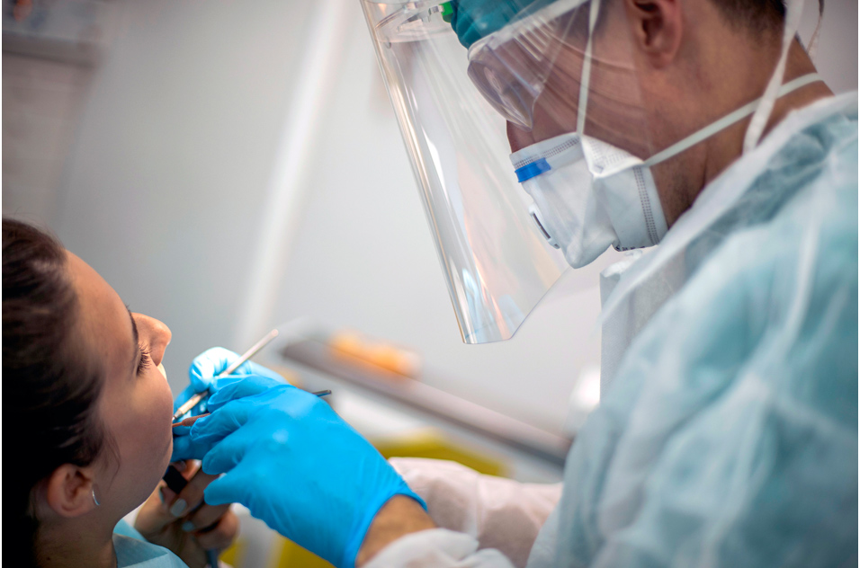 dentist looks in a person&#39;s mouth