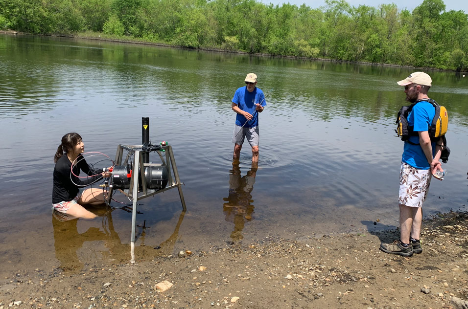 Irene Hu and Harry Hemond work in the Concord River