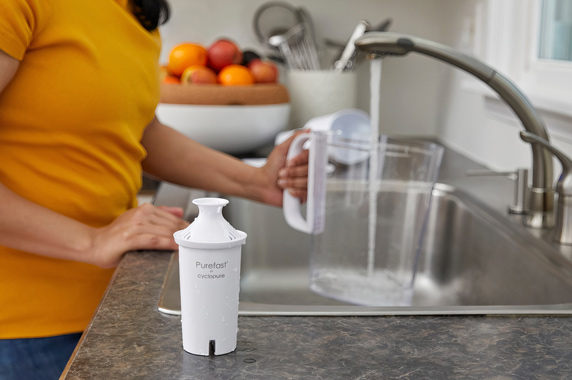 Woman fills water filter pitcher