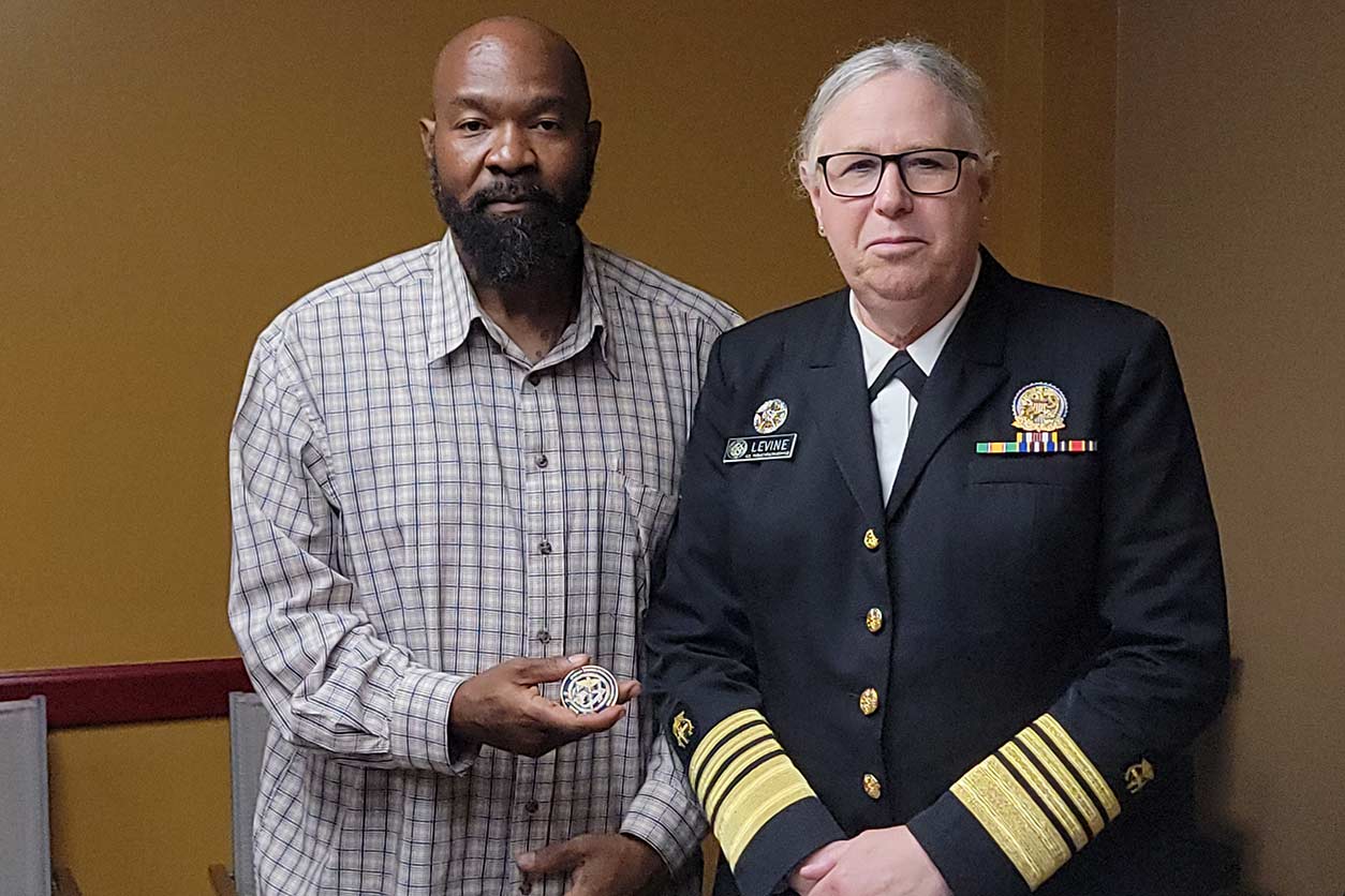 Admiral Rachel Levine, M.D., presents presented Tristan Mack, a worker training program success story, with the U.S. Public Health Service Coin.