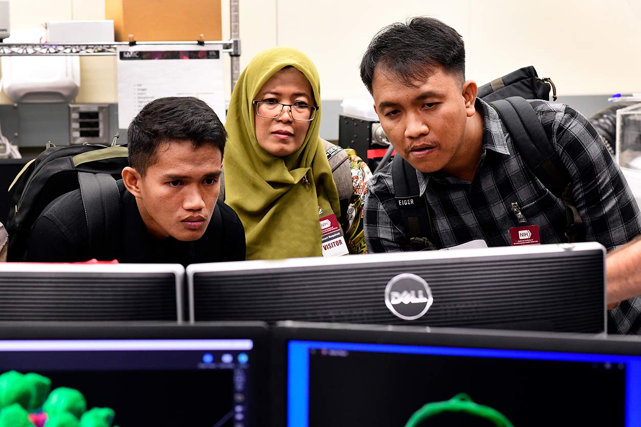 Ricky Azrofi Samara, left, Endang Puspa Sari, center, and Ariyoga Pratama, right, look at a 3D video of a chromosome on a tour of the Fluorescence Microscopy and Imaging Center