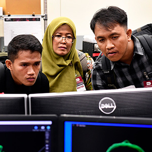 Ricky Azrofi Samara, left, Endang Puspa Sari, center, and Ariyoga Pratama, right, look at a 3D video of a chromosome on a tour of the Fluorescence Microscopy and Imaging Center