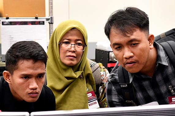 Ricky Azrofi Samara, left, Endang Puspa Sari, center, and Ariyoga Pratama, right, look at a 3D video of a chromosome on a tour of the Fluorescence Microscopy and Imaging Center
