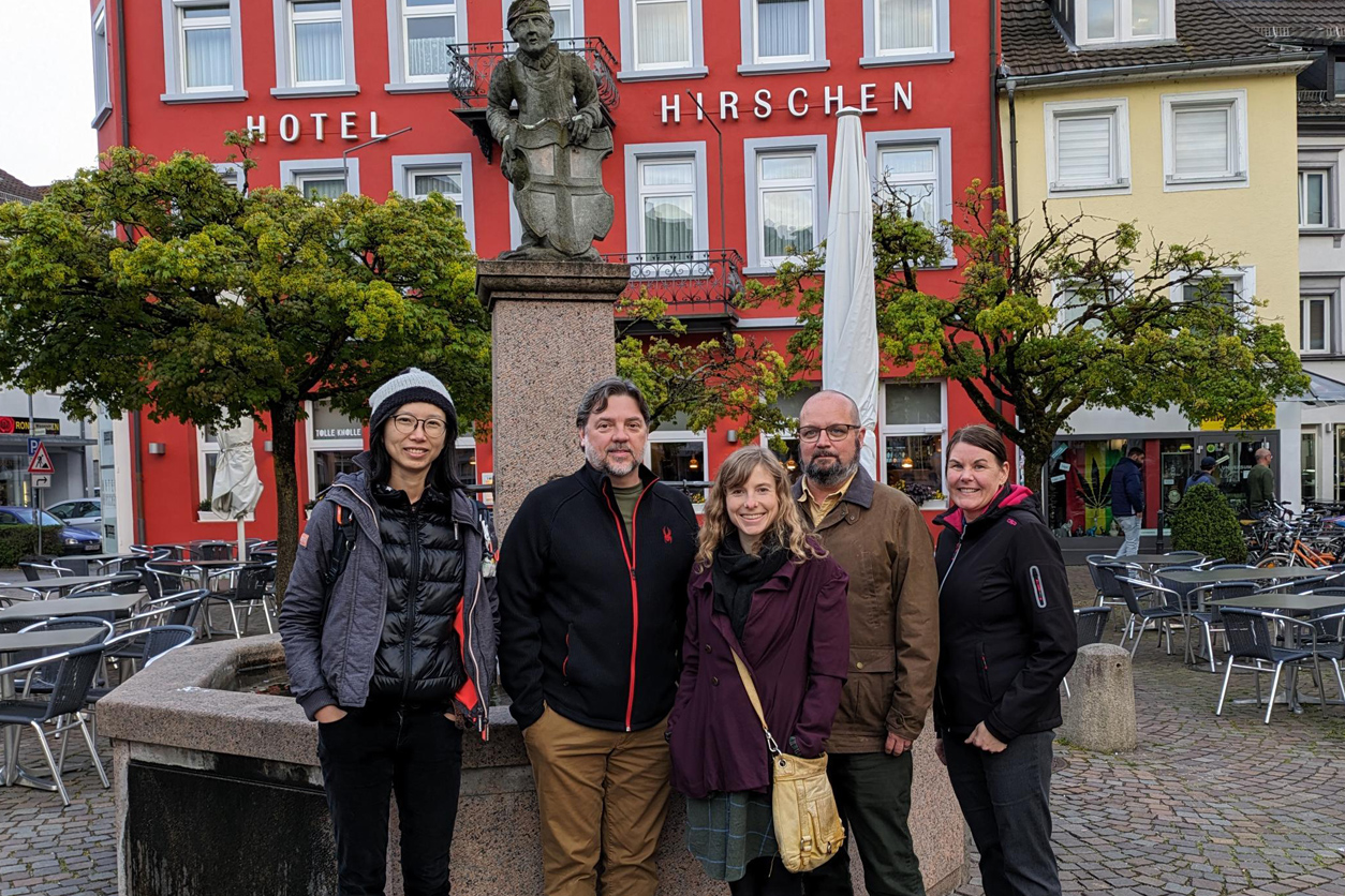 Hsieh, Stanko, Kreutz, McPherson and Hogsberg outside in front of fountain in a city square