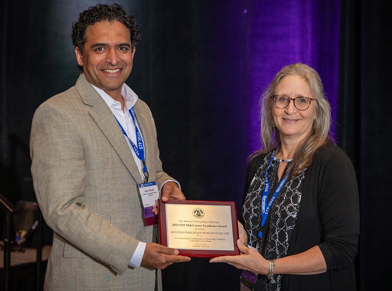 Arun Pandiri, Ph.D., left, receives award from Kris Helke, D.V.M., Ph.D., right