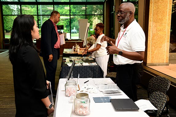 Planning committee stand behind tables at the seminar