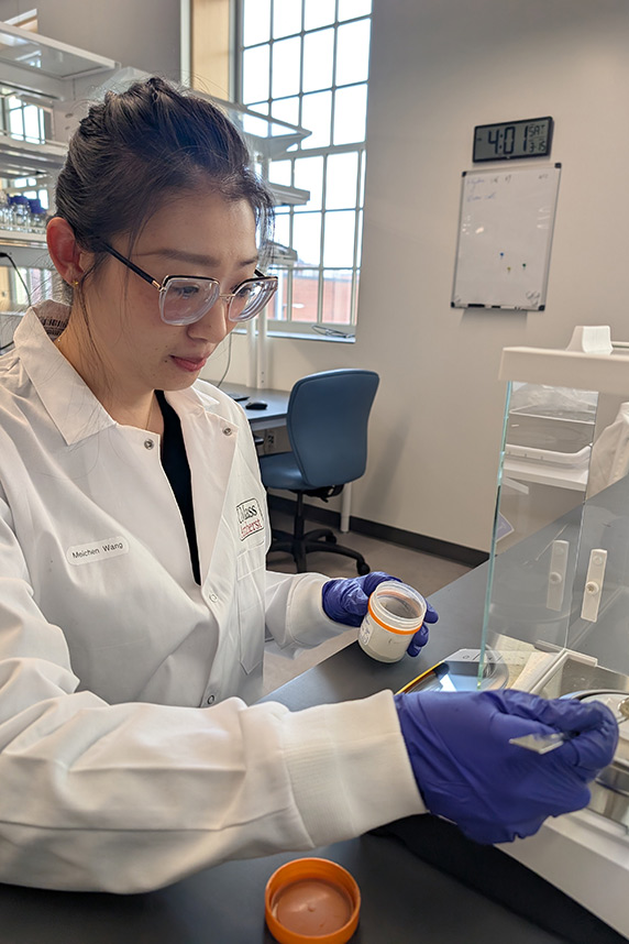 Meichen Wang, Ph.D., in safety gear, running test in lab