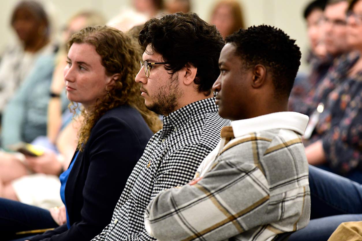 Fellows, left to right, Katherine Patterson, Bryan Ochoa, and Emmanuel Dediavoukana listen to presentations from their peers. (Photo courtesy of Steve McCaw / NIEHS)