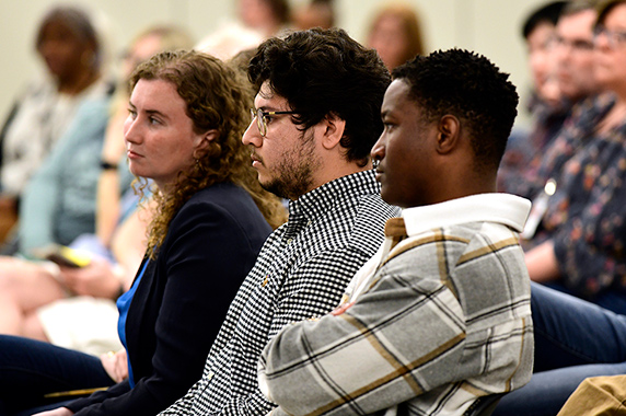 Fellows, left to right, Katherine Patterson, Bryan Ochoa, and Emmanuel Dediavoukana listen to presentations from their peers. (Photo courtesy of Steve McCaw / NIEHS)