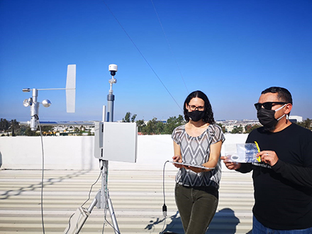 Lara Schwarz and Javier Emmanuel Castillo Quiñones on a rooftop with research equipment