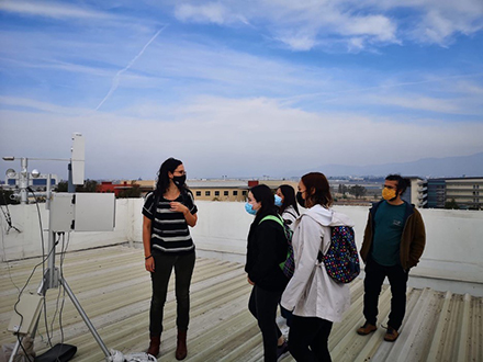 researchers and students on a rooftop with monitoring equipment