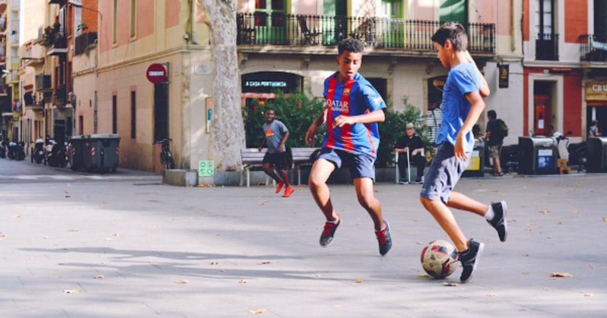 children playing soccer in the street