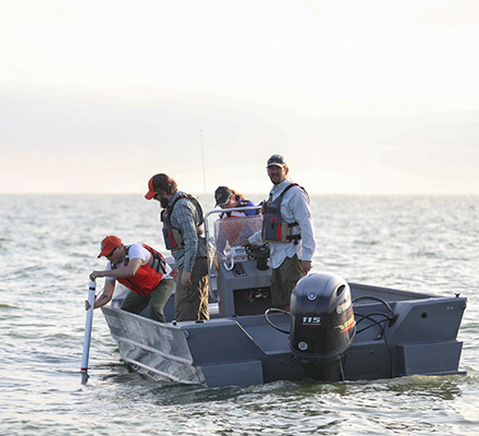 four people on a boat in the water