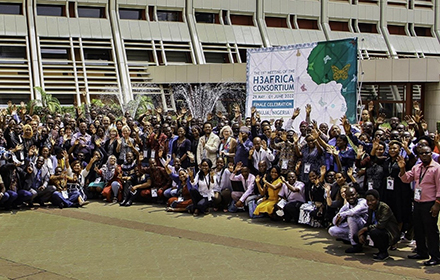 large crowd gathered in front of an H3AFRICA Consortium banner