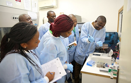 group of researchers performing lab work and taking notes