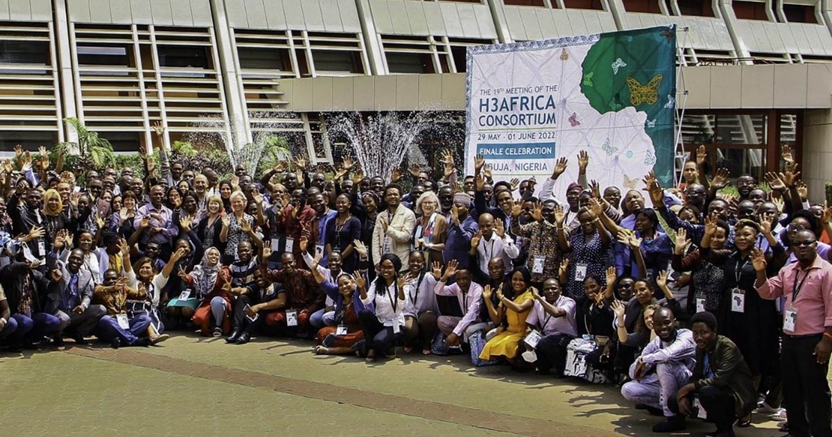 large crowd gathered in front of an H3AFRICA Consortium banner
