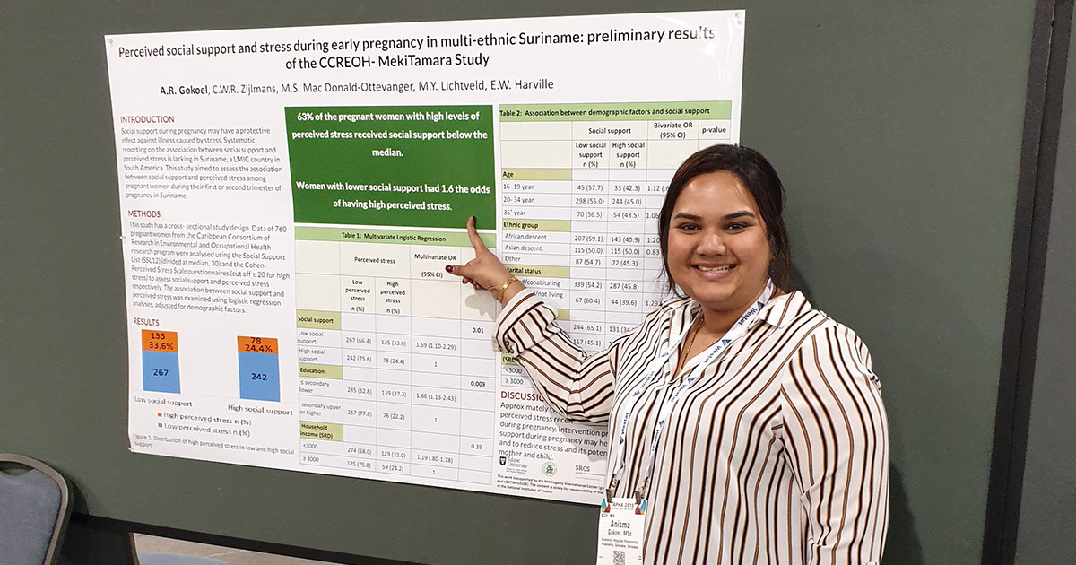 Anisma Gokoel pointing to a presentation poster