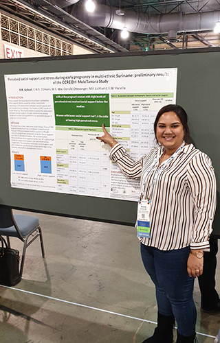 Anisma Gokoel pointing to a presentation poster