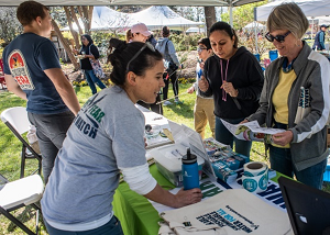 People gathered around an outdoor table at Go Fish Fest