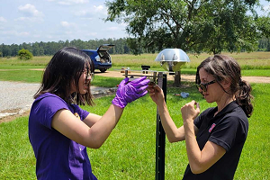 Two people setting up a device outdoors