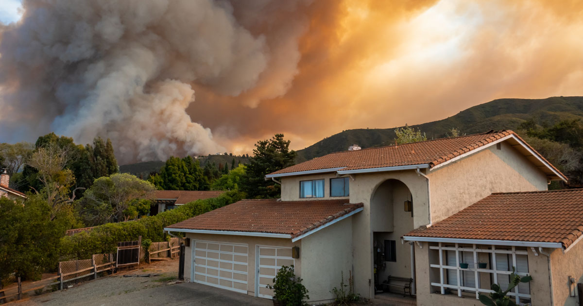wildfire raging behind a house