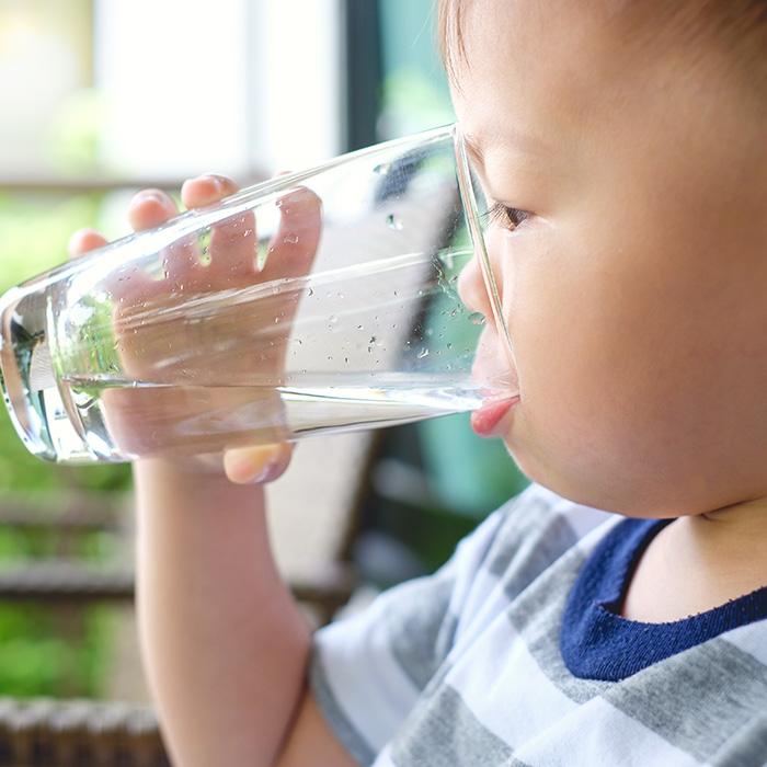 child drinking a glass of water
