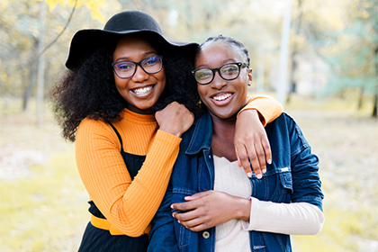 Two young Black women smiling and posing for a candid 
