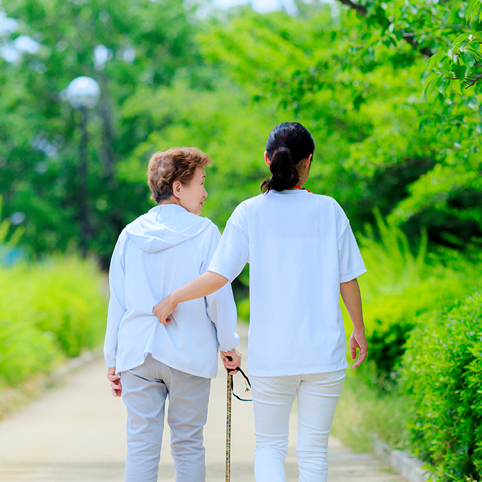 lady walking with an older lady with lots of greenery