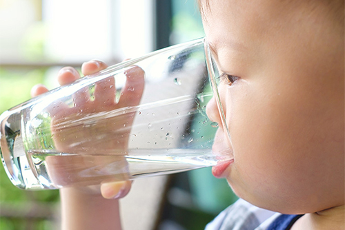 child drinking a glass of water