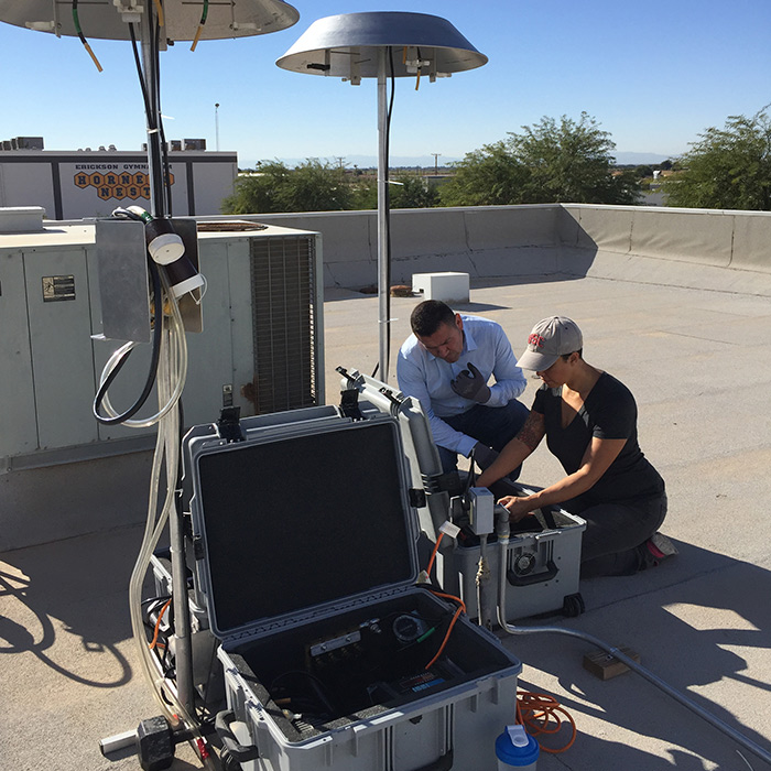 Lisa Valencia shows CCV staff member Humberto Lugo how to set up and operate an air sampler