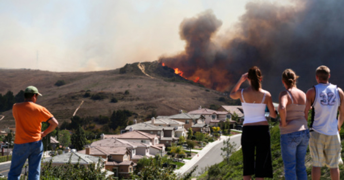 people watching a wildfire in the distance