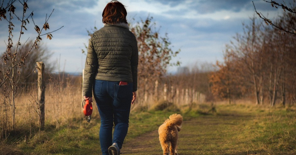 woman walking a dog outside