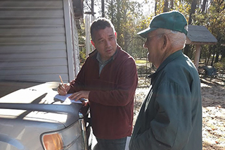 Andrew George speaking with property owner